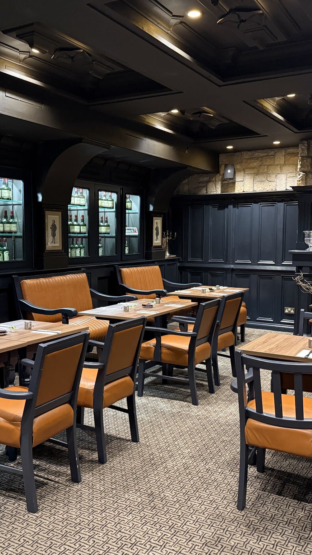 Another view of The Library, with its dark wood panelling and leather seating